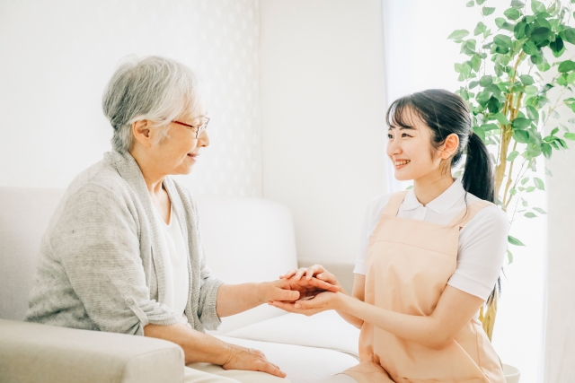 老人に寄り添う女性の写真